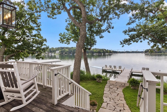 wooden deck with a water view and a boat dock