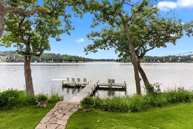 dock area featuring a lawn and a water view