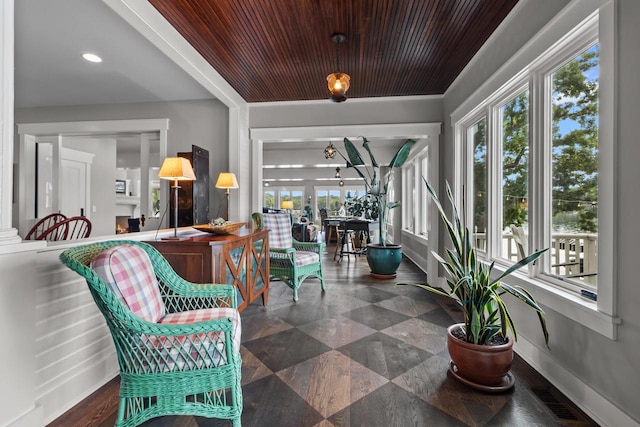 sunroom featuring wooden ceiling and a healthy amount of sunlight