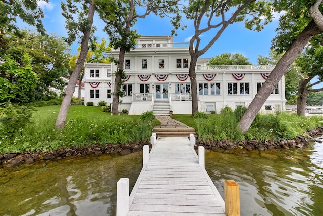 dock area with a lawn and a water view