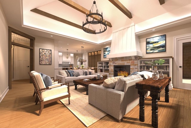 living room with beamed ceiling, light wood-type flooring, a chandelier, and a stone fireplace