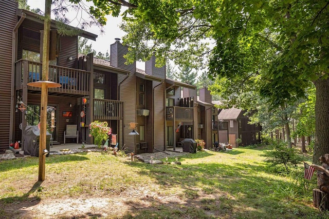 exterior space with a balcony and a lawn