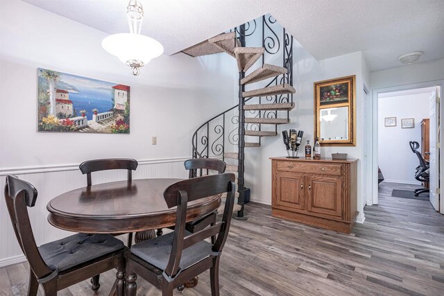 dining room with hardwood / wood-style flooring and a textured ceiling