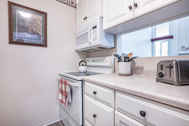 kitchen with white cabinetry and white appliances