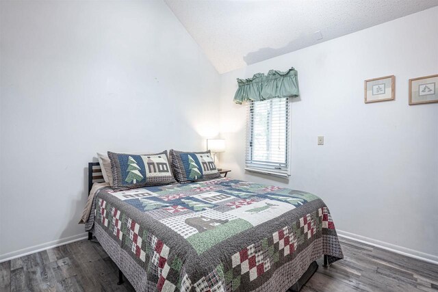 bedroom featuring vaulted ceiling and dark hardwood / wood-style floors