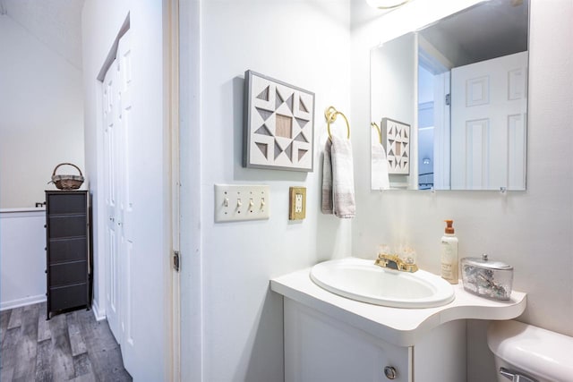 bathroom featuring vanity, hardwood / wood-style floors, and toilet