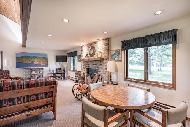 dining space featuring a baseboard radiator, a brick fireplace, and carpet flooring