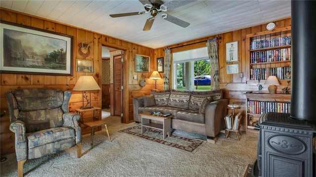 12810 N County Highway T, Hayward, WI 54843 - living area with carpet floors, wood walls, a wood stove, ceiling fan, and wooden ceiling