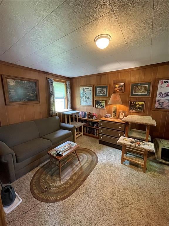 carpeted living room featuring wooden walls