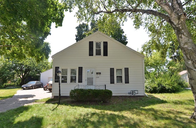 bungalow-style home with a front yard