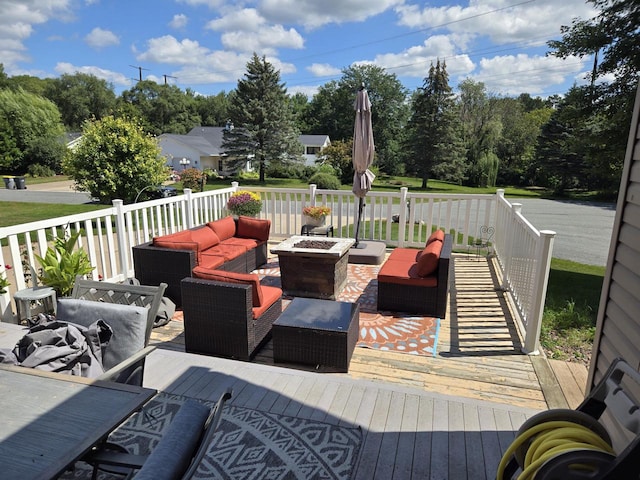 deck featuring an outdoor living space with a fire pit