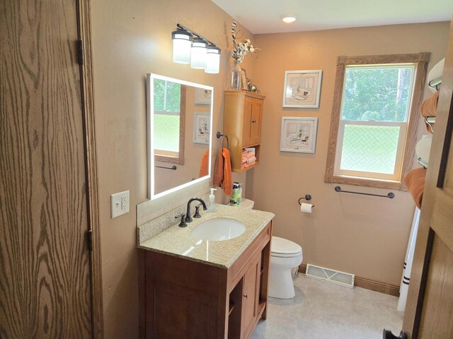 bathroom featuring tile patterned flooring, toilet, and vanity