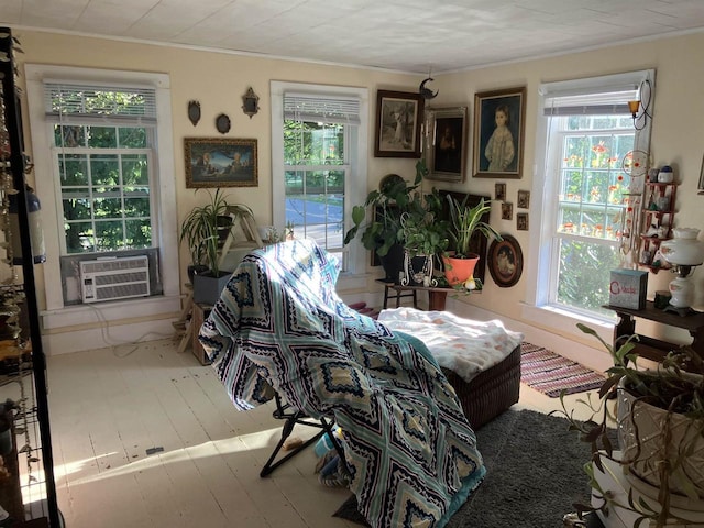 interior space featuring cooling unit, crown molding, and hardwood / wood-style floors