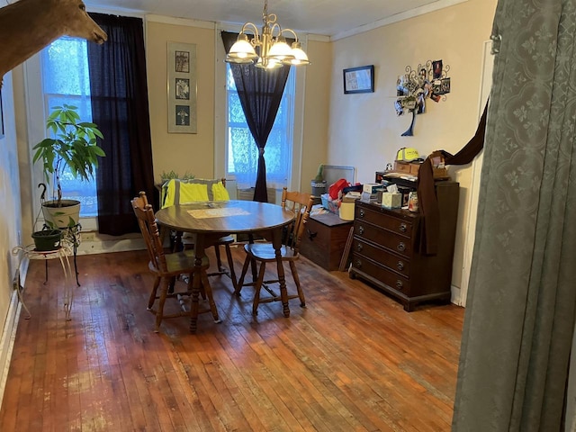 dining area featuring hardwood / wood-style floors, a chandelier, and crown molding