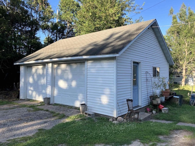 view of home's exterior with a garage and an outbuilding