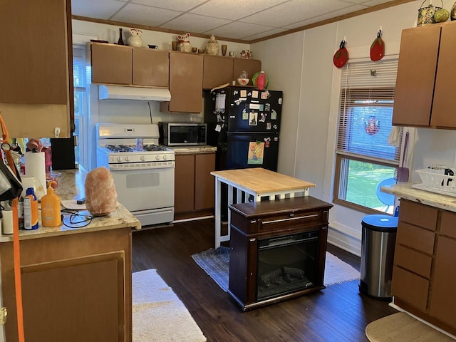 kitchen featuring white gas range, black refrigerator, ornamental molding, a paneled ceiling, and dark hardwood / wood-style floors