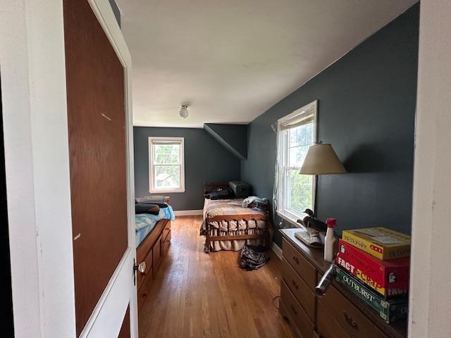 bedroom with multiple windows and hardwood / wood-style flooring