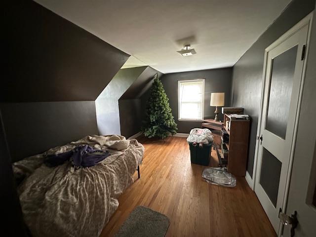 bedroom featuring hardwood / wood-style flooring and vaulted ceiling