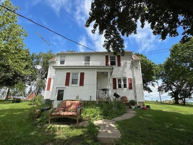 rear view of property featuring a lawn