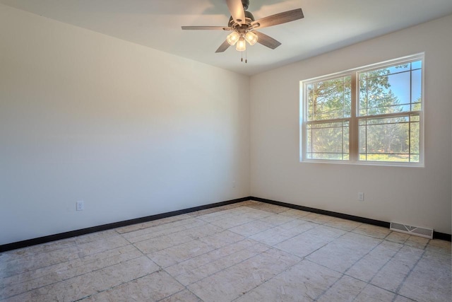 tiled empty room with ceiling fan and plenty of natural light