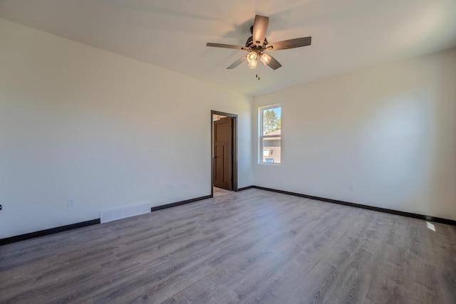 empty room featuring hardwood / wood-style flooring and ceiling fan