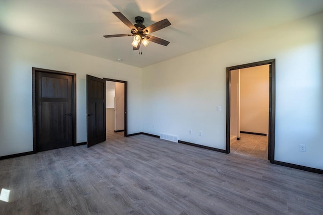 unfurnished bedroom with ceiling fan and hardwood / wood-style flooring