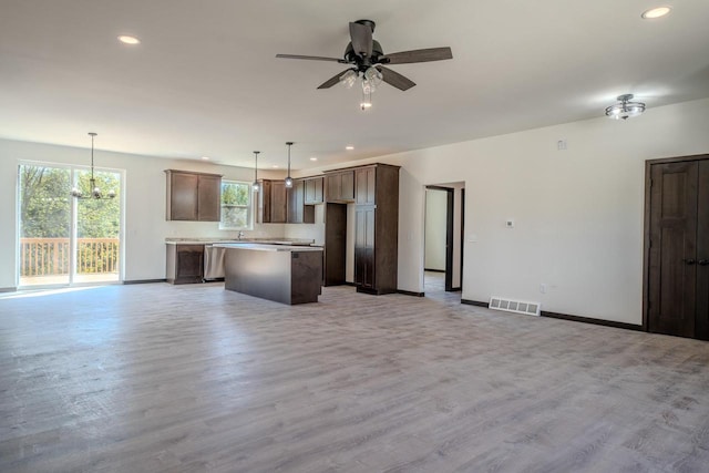 kitchen featuring a center island, decorative light fixtures, light hardwood / wood-style floors, stainless steel dishwasher, and ceiling fan