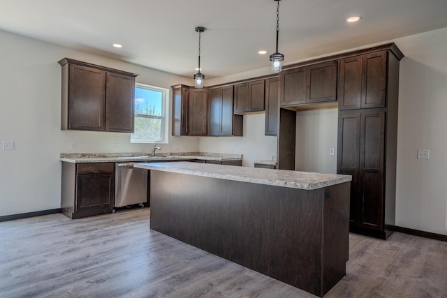 kitchen with dishwasher, light hardwood / wood-style floors, decorative light fixtures, dark brown cabinets, and a center island