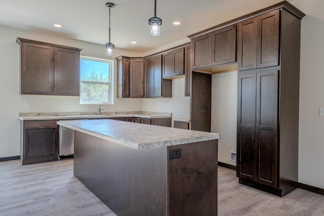 kitchen with light wood-type flooring, dark brown cabinets, pendant lighting, and a kitchen island