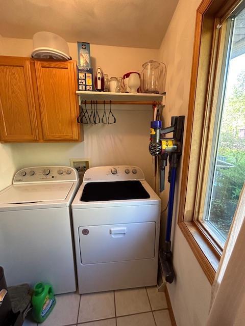 laundry room with cabinets, independent washer and dryer, and light tile patterned flooring