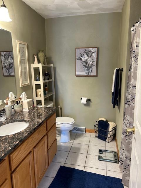 bathroom featuring tile patterned floors, toilet, and vanity