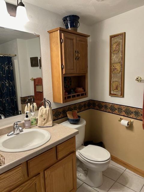 bathroom with tile patterned flooring, vanity, and toilet