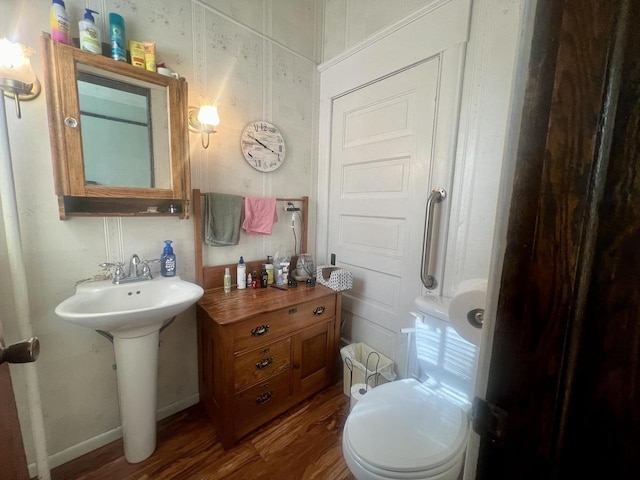 bathroom with hardwood / wood-style flooring, sink, and toilet