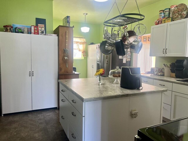 kitchen with a center island, pendant lighting, white cabinets, and a healthy amount of sunlight