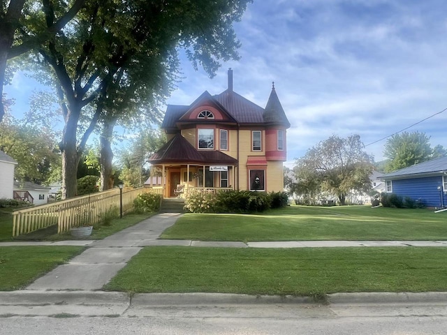 victorian home with covered porch and a front yard