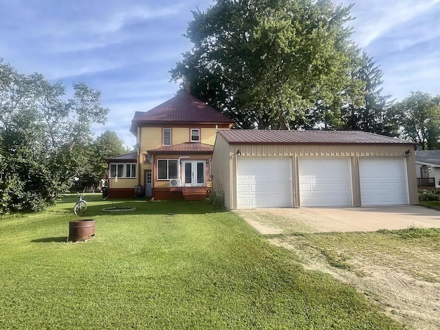 view of front of property with a garage, an outbuilding, and a front lawn