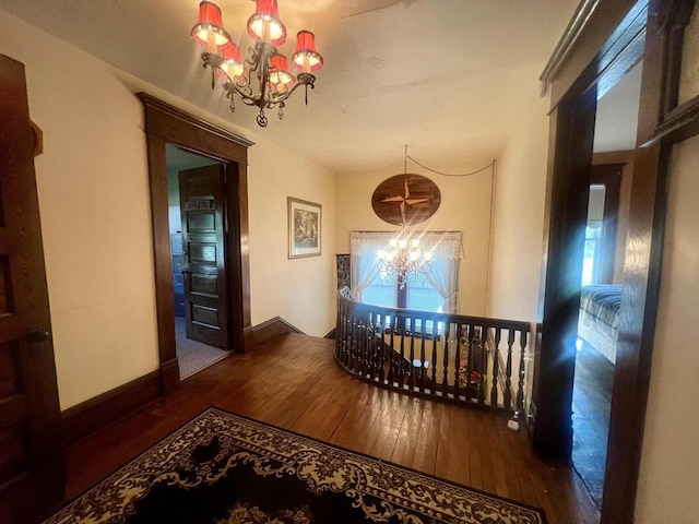 corridor featuring dark hardwood / wood-style floors and an inviting chandelier