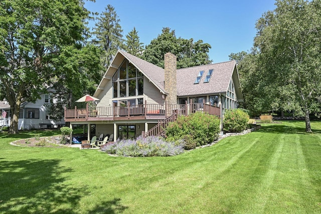 rear view of property featuring a lawn and a deck