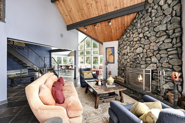 living room with tile patterned flooring, beamed ceiling, high vaulted ceiling, wood ceiling, and a stone fireplace