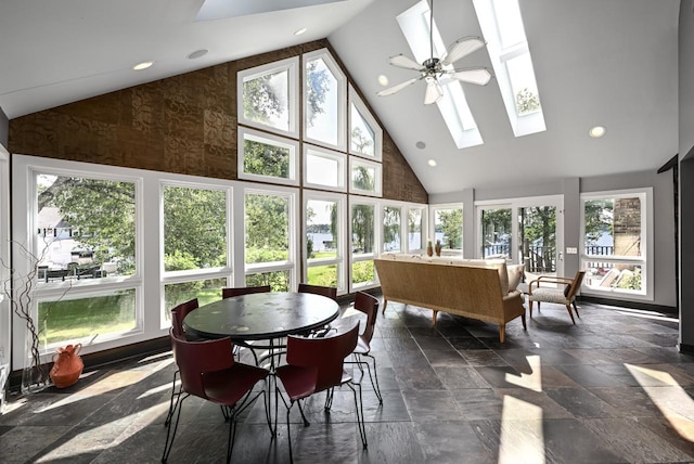 sunroom featuring ceiling fan and vaulted ceiling with skylight