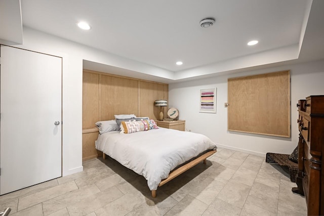 bedroom featuring light tile patterned floors and a raised ceiling