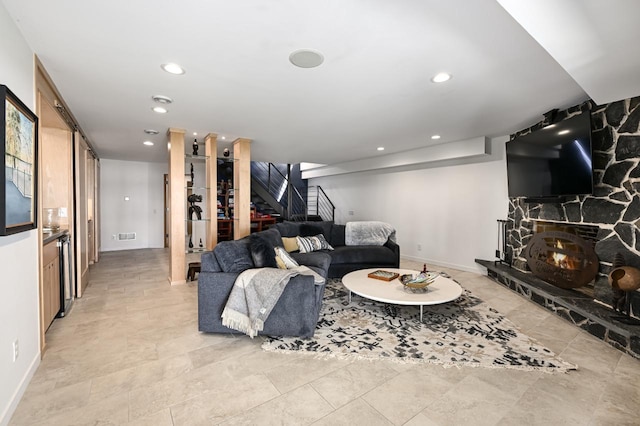 living room with light tile patterned floors and a stone fireplace