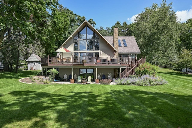 back of property featuring a deck and a lawn