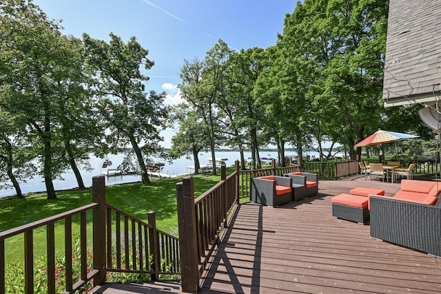 wooden deck featuring a lawn and a water view