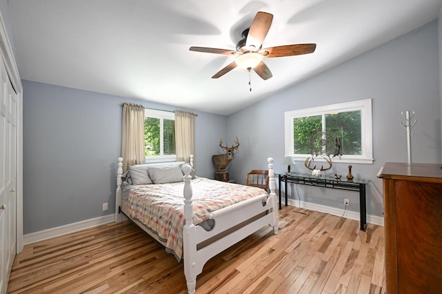 bedroom featuring ceiling fan, a closet, lofted ceiling, and light wood-type flooring