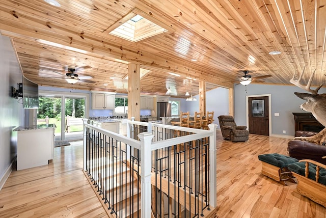 hall with light wood-type flooring, a skylight, and wood ceiling