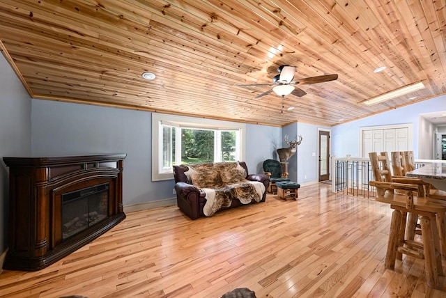 living room featuring light wood-type flooring, vaulted ceiling with skylight, wooden ceiling, and ceiling fan