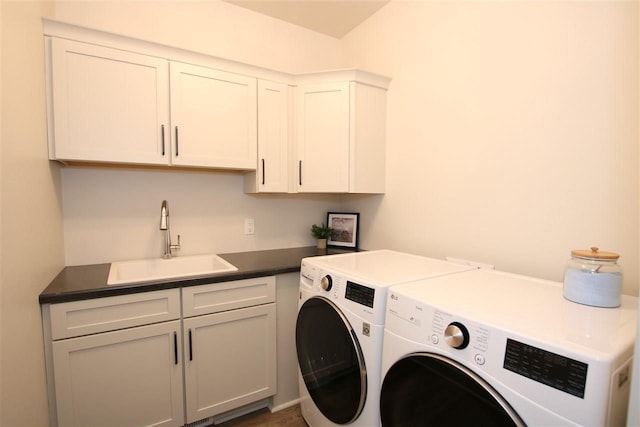 washroom with cabinet space, separate washer and dryer, and a sink