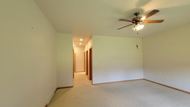 spare room with light colored carpet and ceiling fan