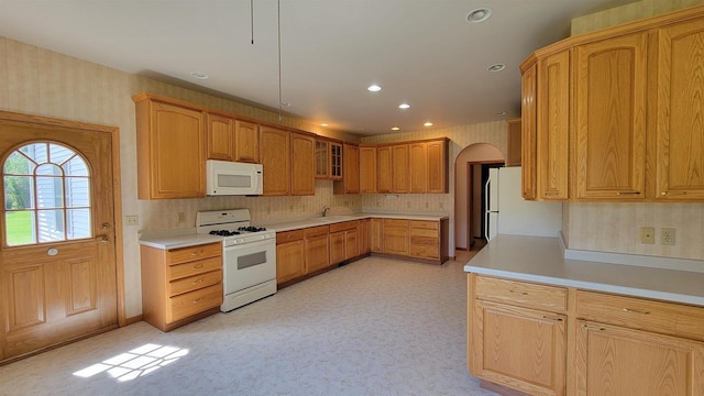 kitchen with backsplash, sink, and white appliances